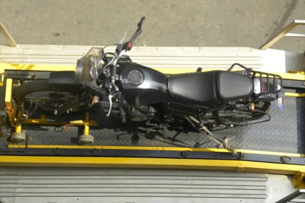 Recovery vehicle transporting broken motorbike from roadside safely