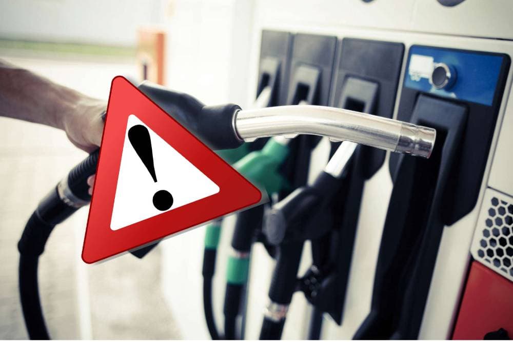 Technician draining wrong fuel from car tank at roadside emergency service