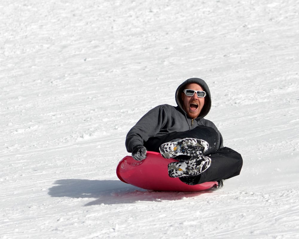 Buddy sledding down the sledding hill in Rocky Mountain National Park