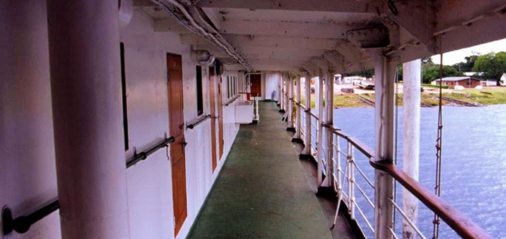 looking down bridge deck with cabin doors to the left and open balcony to right