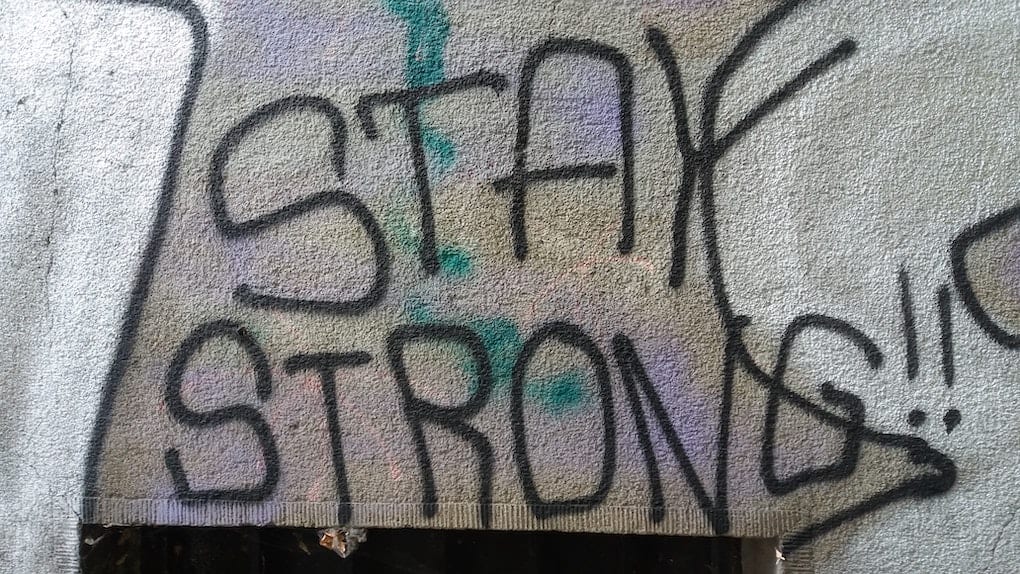 graffiti on wall that reads "stay strong"