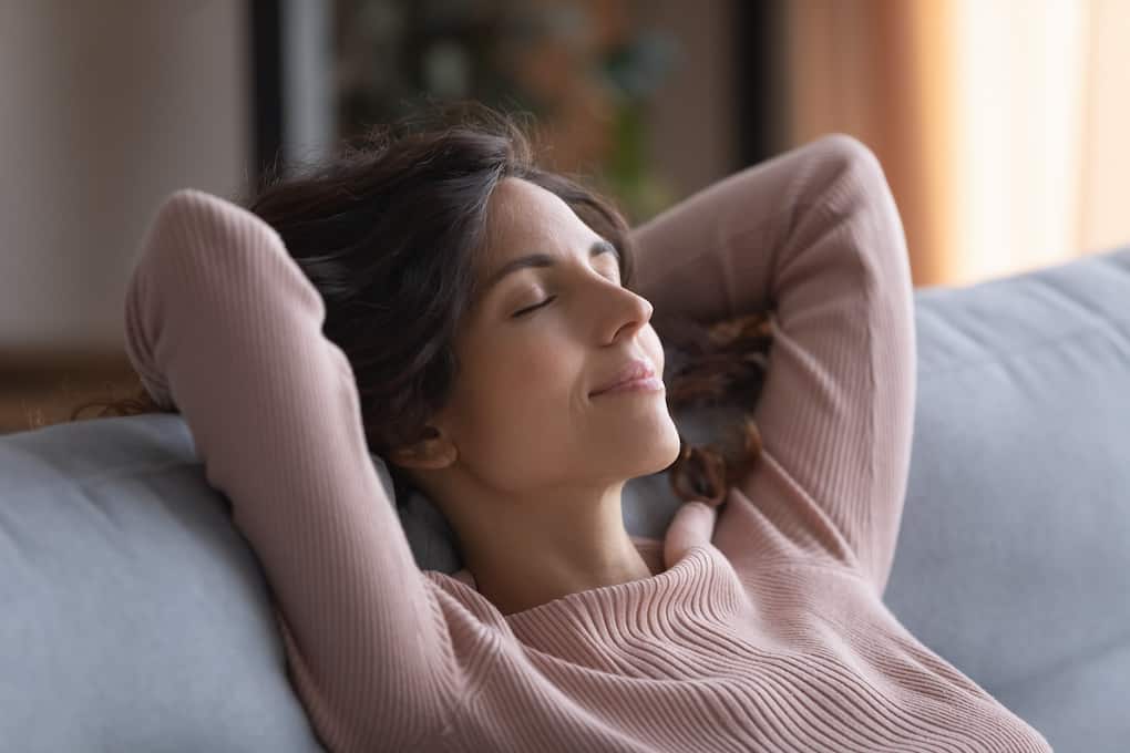 woman slightly smiling with eyes closed looking calm