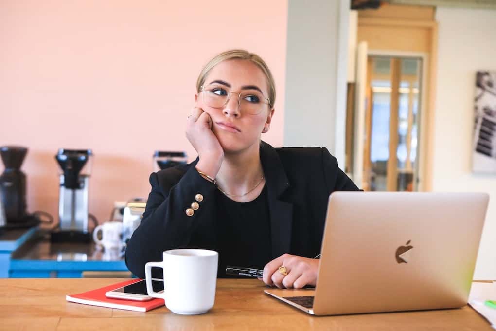 woman at work with head on her hand looking bored and fed up