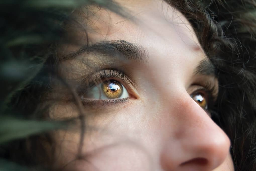 woman gazing into distance with bright hazel coloured eyes