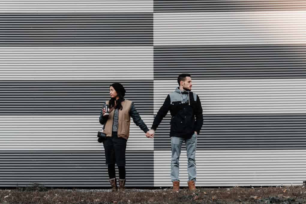 couple holding hands looking in opposite directions