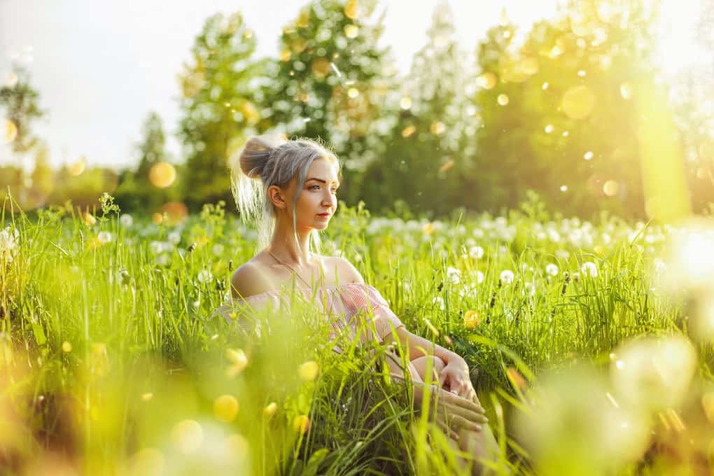 girl sitting in nature among flowers