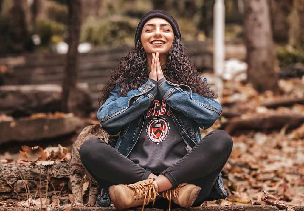 girl sat in prayer smiling