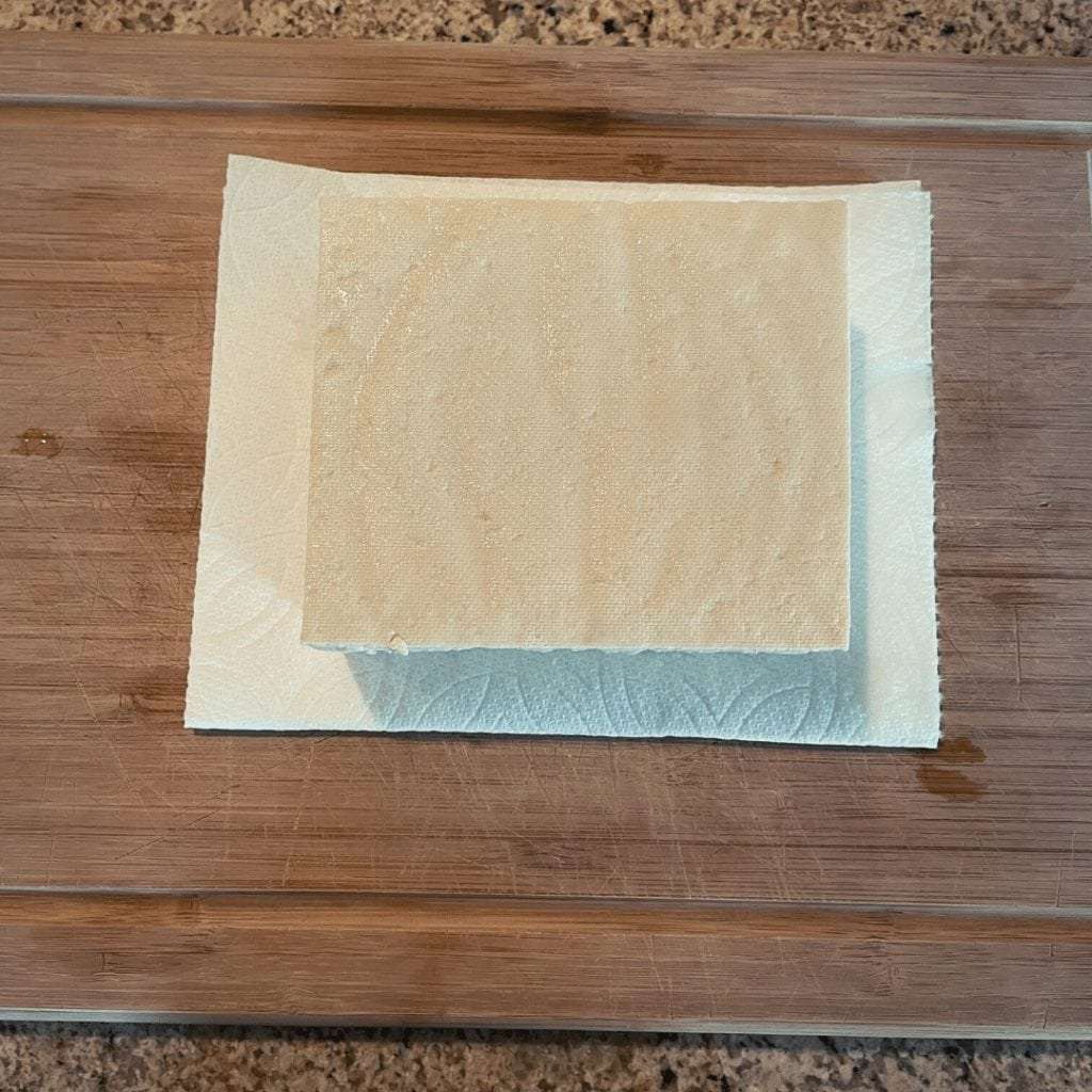 Place tofu on folded paper towels to absorb moisture