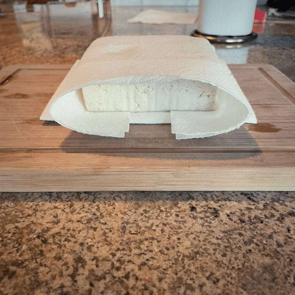 Wrap tofu in paper towels