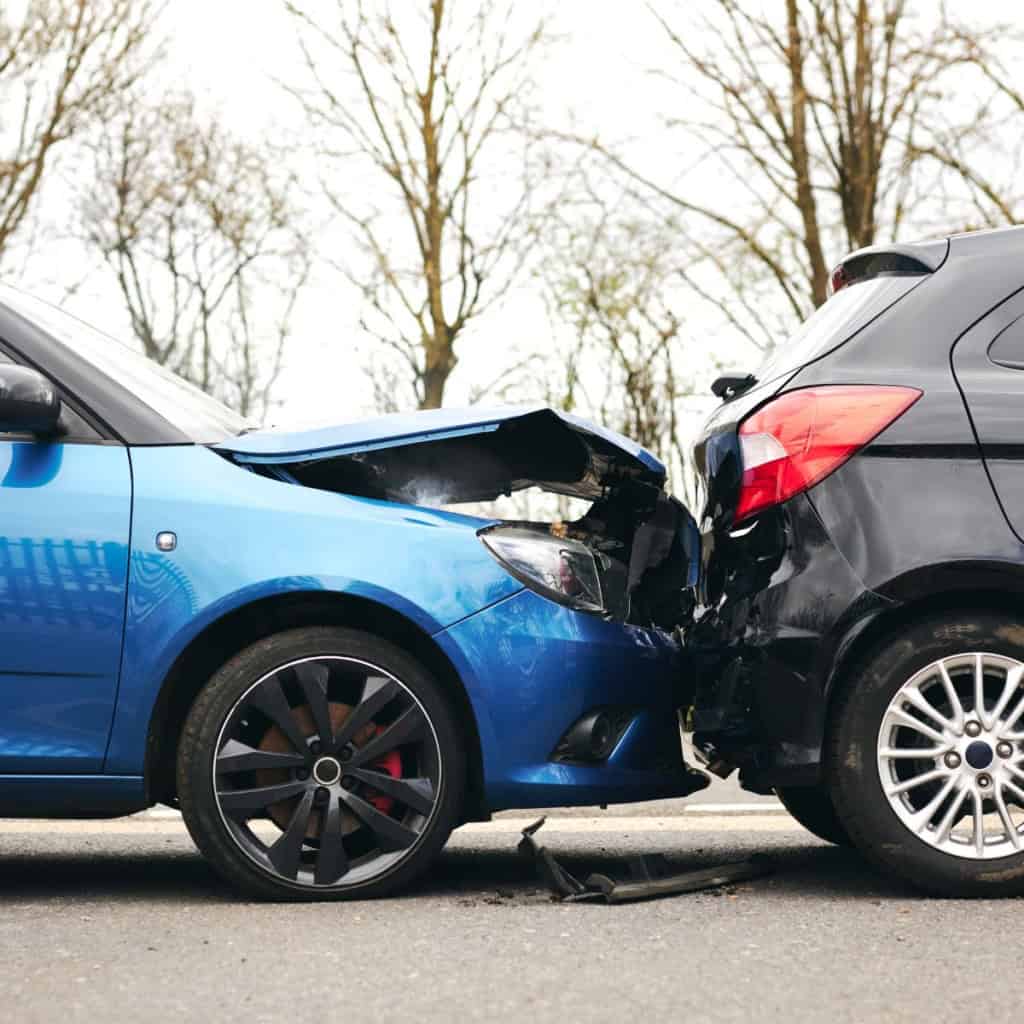 Blue car with damage from a crash into the back of black car. Personal Injury claim