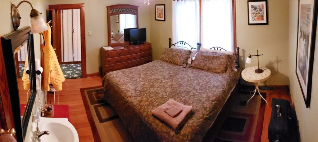 King bed placed in front of 2 windows, TV on dresser and in-room sink make up this room seem like a Elkhart Lakes hotel room