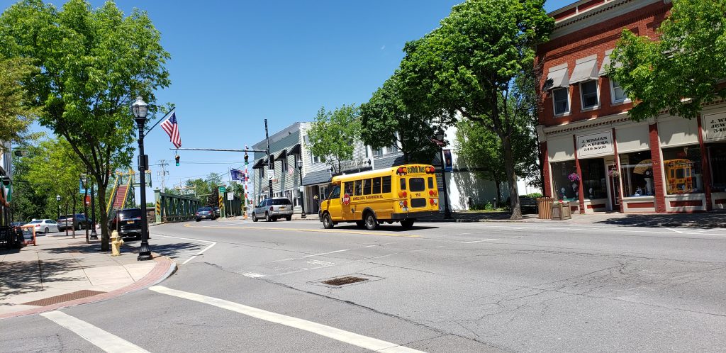 Erie Canal town street scene with American flags, school bus and lift bridge - Spencerport