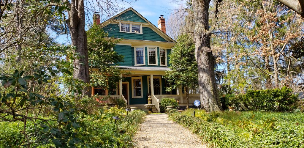 Outside shot of Cumberland Falls Bed and Breakfast, a green post-Victorian home with path leading through gardens of greenery
