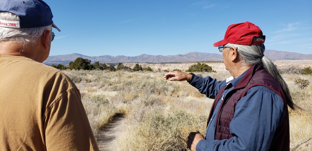 Elmer points towards mountains in background as Allan Kissam from California looks on.