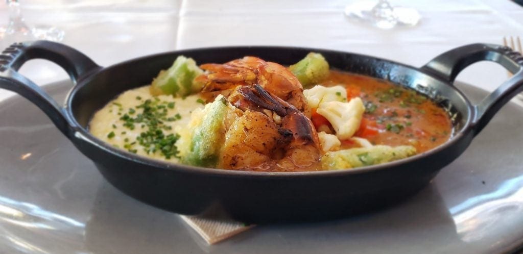 Shrimp and grits in small cast iron serving pan with two handles