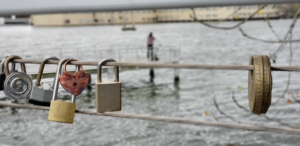 heart-shaped padlock and MasterLock padlocks hang from the cable below the handrails at De Pere Riverwalk, one of the Things to do in Green Bay Wisconsin