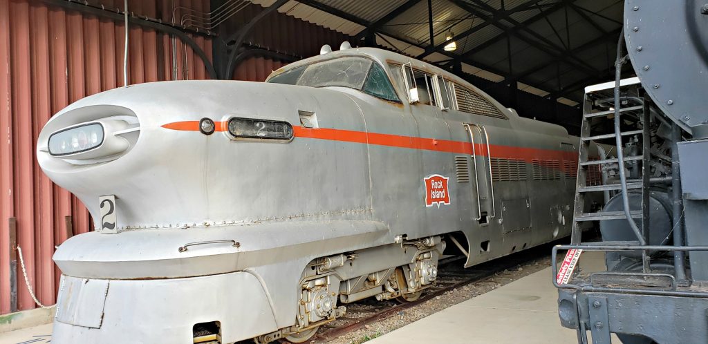 A locomotive with long, greyhound-like nose and aerospace-like small windows sits on track in museum one of the best things to do in Green Bay WI