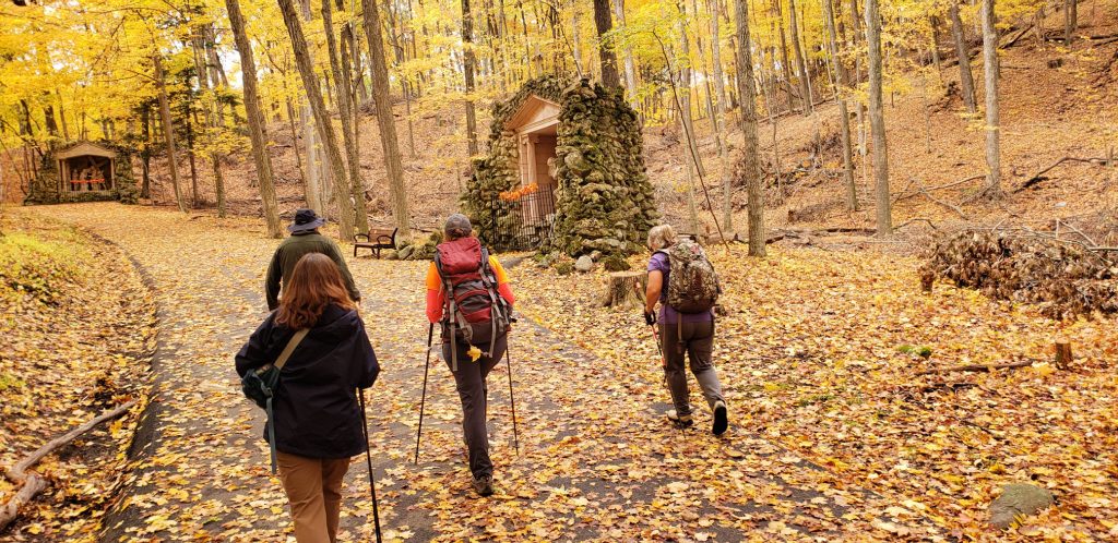 4 hikers stride up steep trail to next station of the cross at Holy Hill WI through the golden leaves