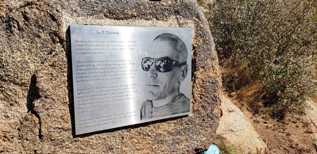 Brushed stainless steel marker with image of Granit Mountain hotshot engraved on it, mounted to granite boulder