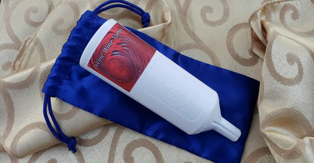 white cylindrical diffuser with smaller end lays on top of blue travel pouch