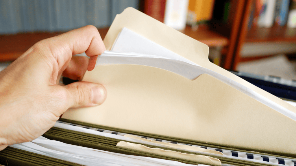 Hand blättert in Papierakten