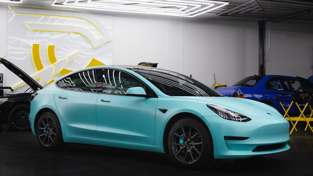 A turquoise Tesla car in a showroom