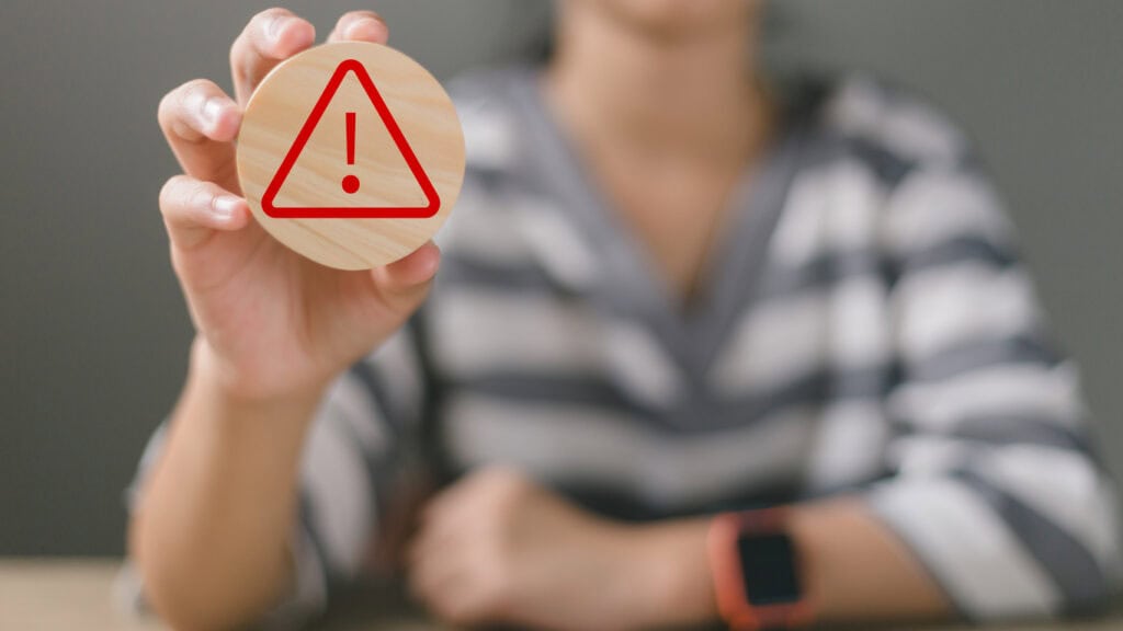 Hand holding wooden with an Exclamation mark or Warning sign with copy space concept for attention symbol, Cautionary Warning, safety, hazard, caution, danger. safety program