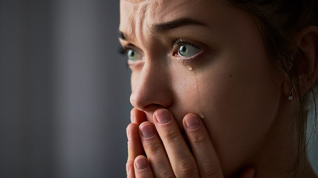 close up of woman crying, tears falling down cheeks