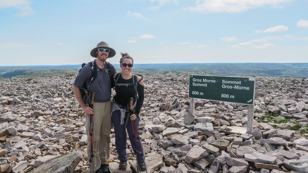 Brooke and Buddy posing at the Gros Morne Mountain Summit sign with an altitude of 806m