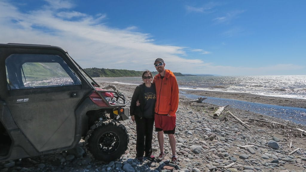 Brooke and Buddy posing next to the ATV on the beach