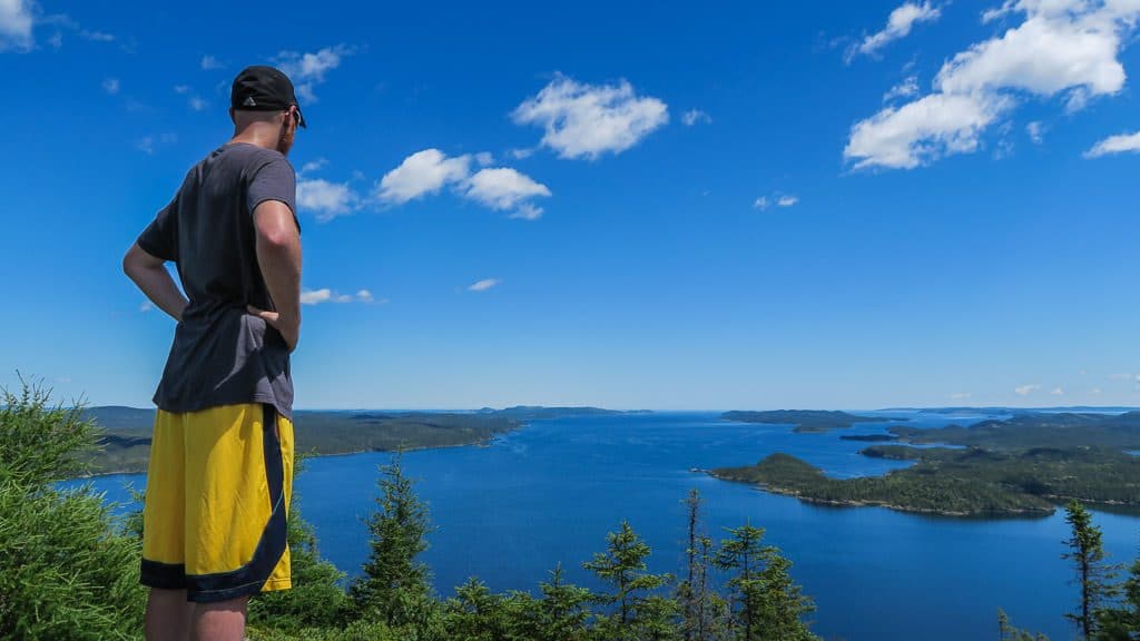 Buddy looking for whales in the ocean from a view point during a hike in Terra Nova National Park