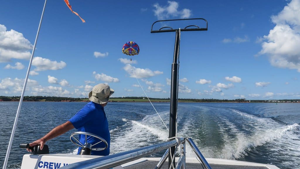 The captain of the boat watching Brooke para sail while he controls the boat speed