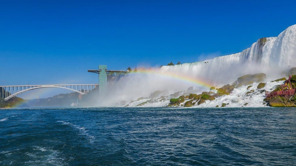 Niagara Falls from our hornblower cruise, looking back towards the pedestrian Rainbow Bridge, with a rainbow next to it.