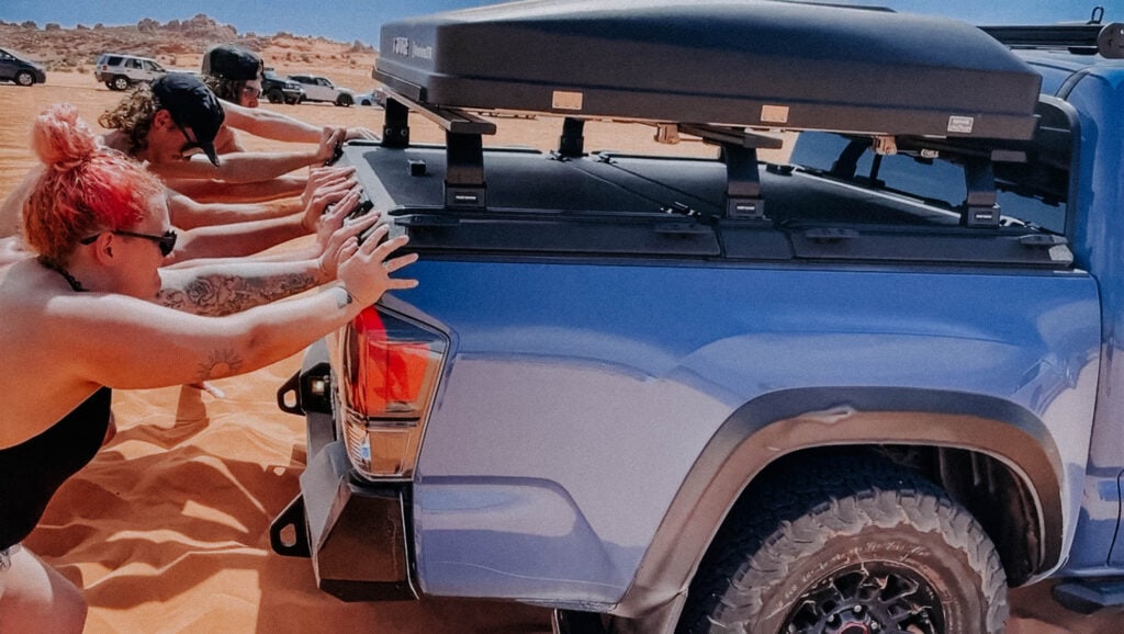 Pushing a Toyota Tacoma out of the sand