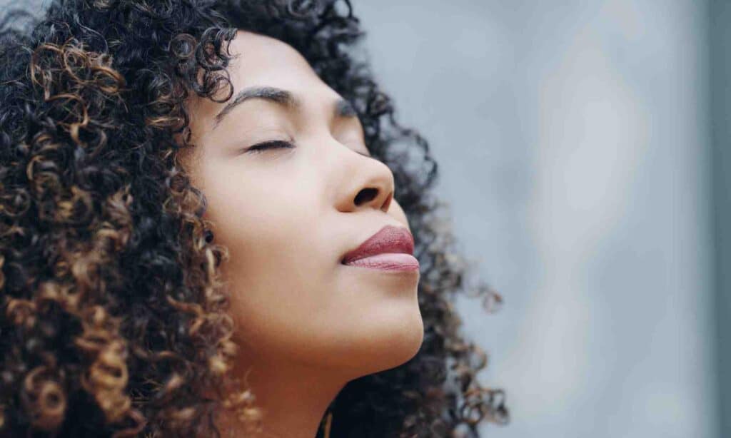black woman breathing in with eyes closed