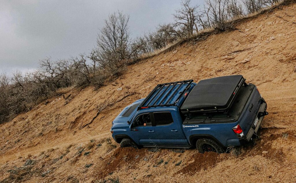 Blue Toyota Tacoma sliding down a hill