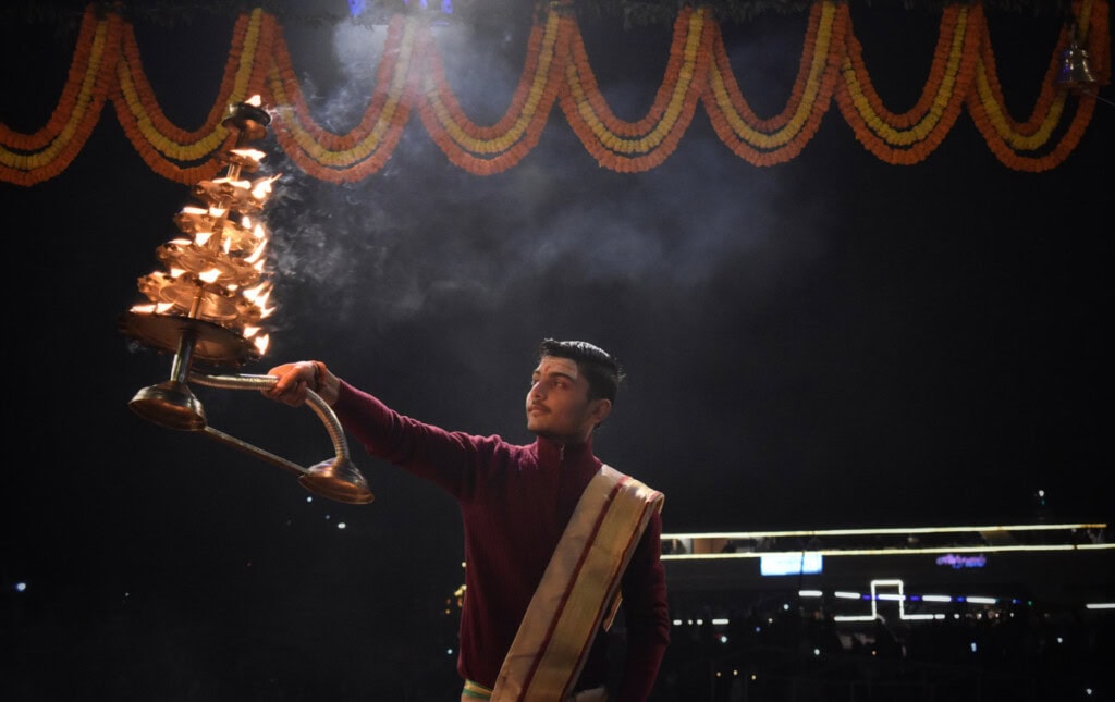 Hindu priest holding a big aarathi lit with diyas at Banaras
