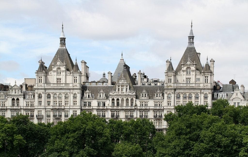 a white long building modeled after a French chateau is where the Royal Horseguards Hotel is located