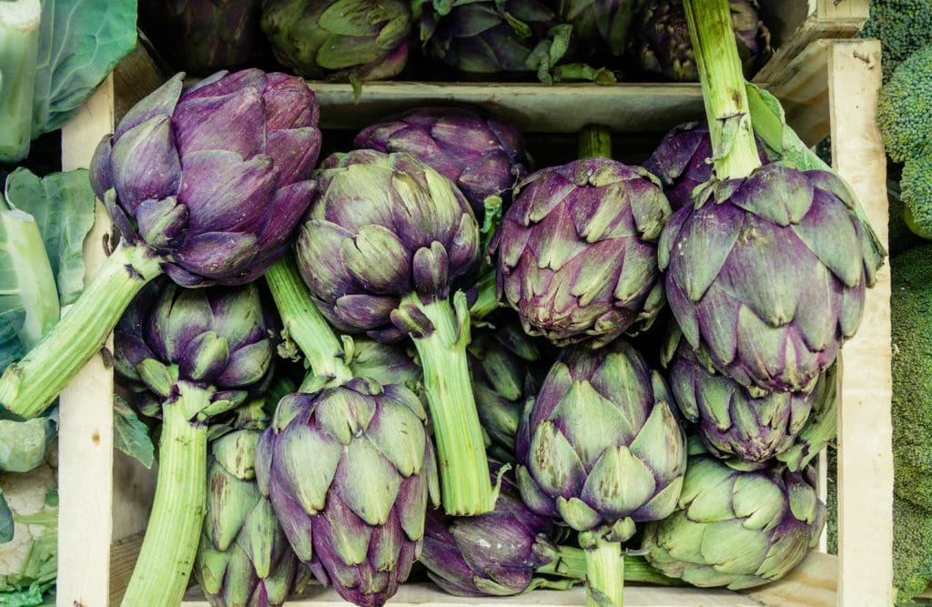 How to cook artichokes article photo - raw purple artichokes in a farm crate