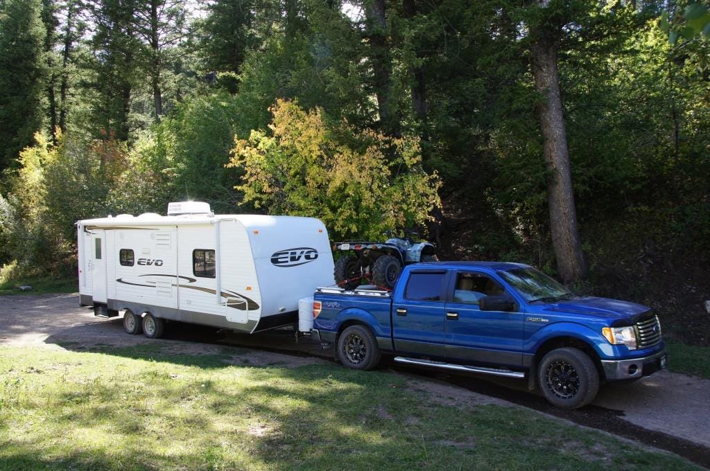 Blue F-150 towing a travel trailer camper