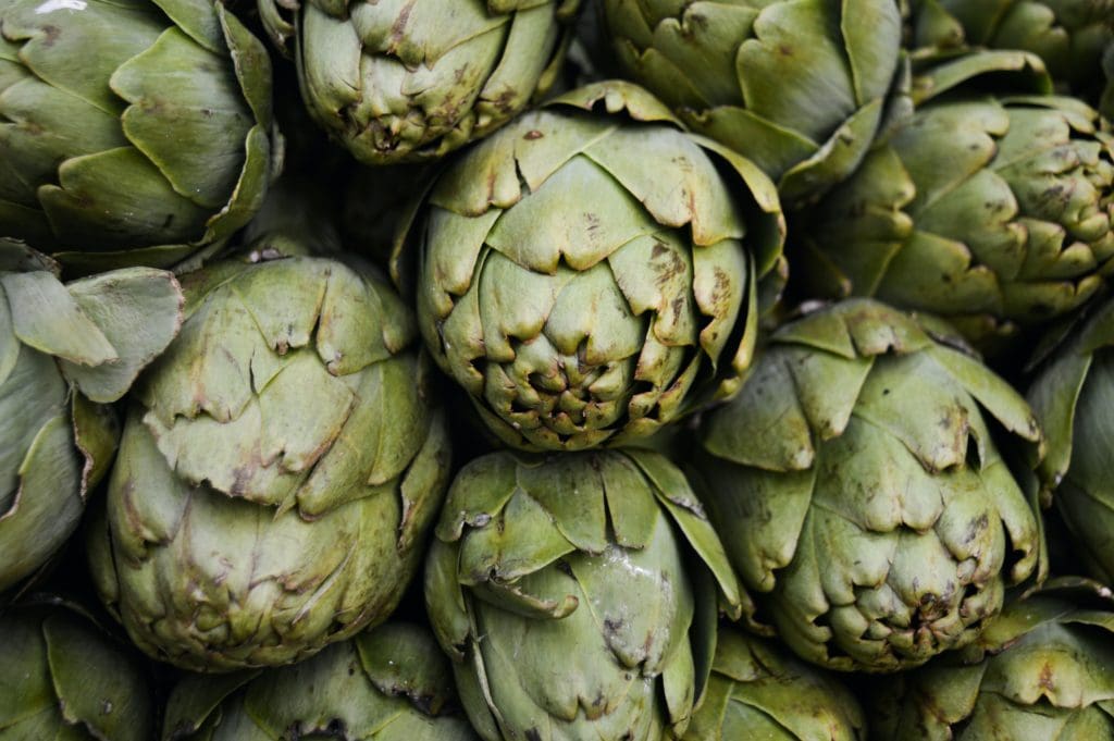 How to cook artichokes article photo - raw green artichokes in a pile