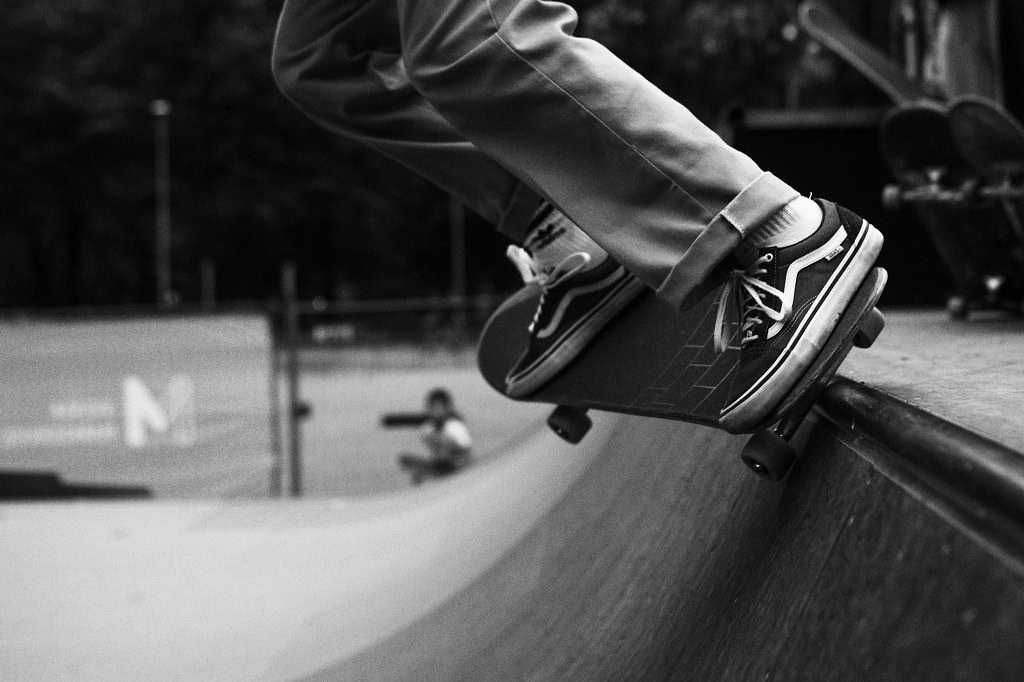 A skateboarder at the top of a half pipe.