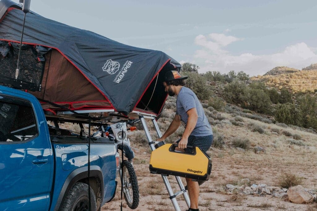 Man Walking up ladder to rooftop tent