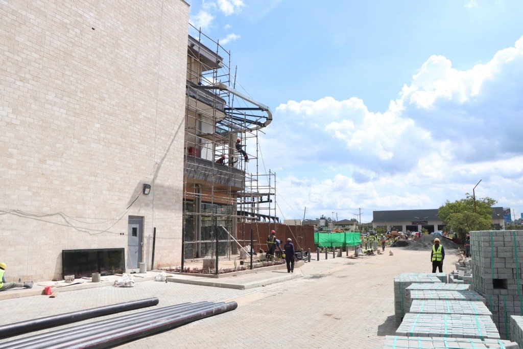 Scaffolding, construction materials, and workers beside a large building