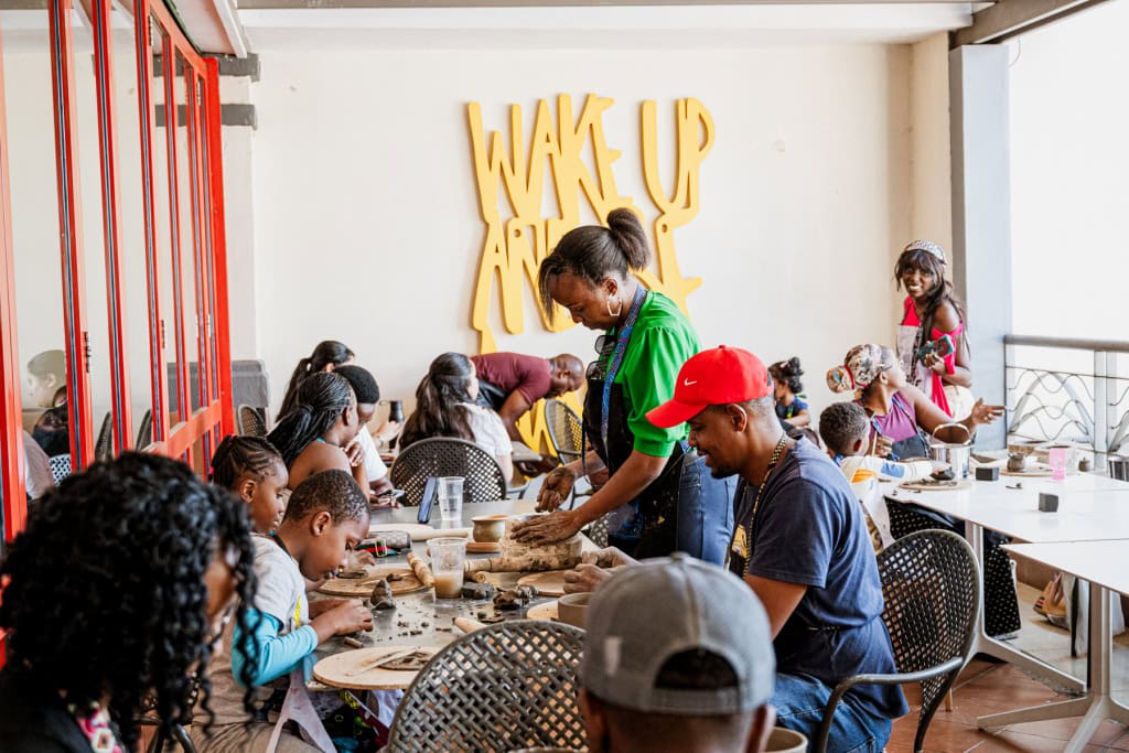 A busy group of participants making pottery together around tables