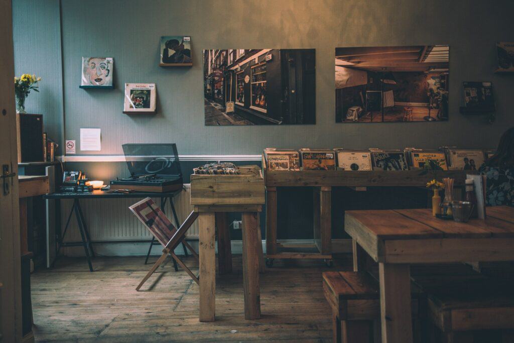 brown wooden dining table inside room with dark walls and a large gallery wall of photos