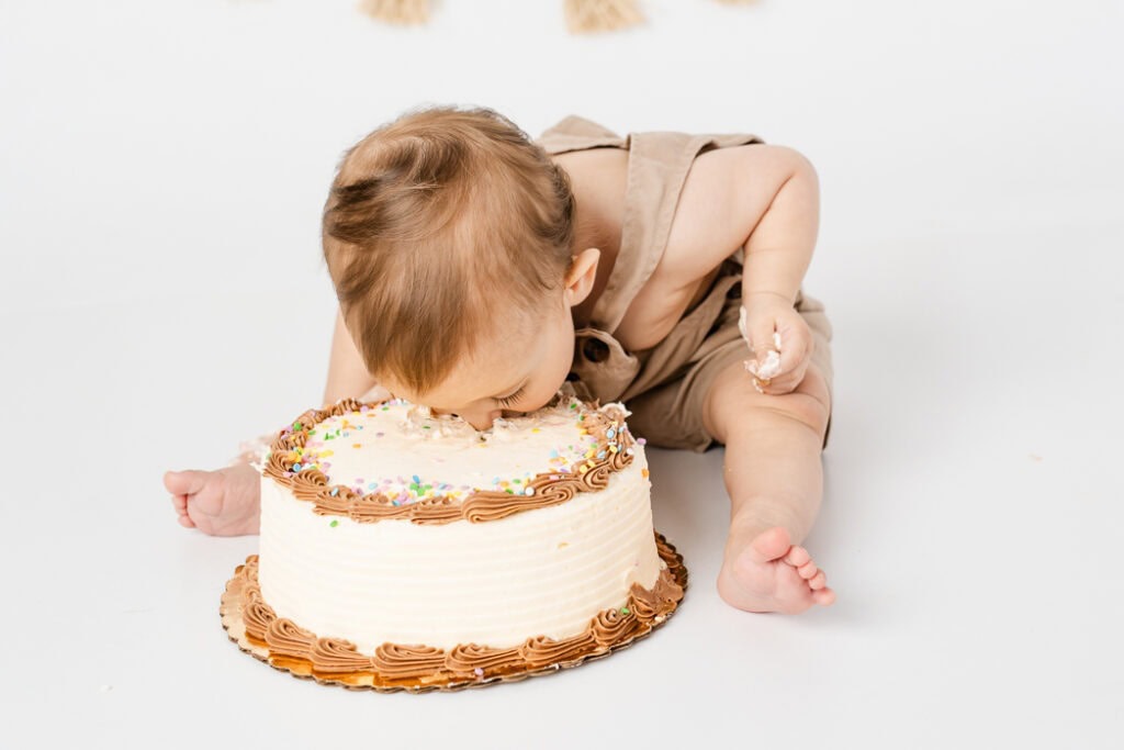 funny baby smashing the cake during cake smash photoshoot in CT