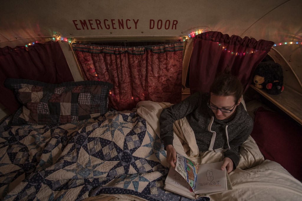 reading inside a converted school bus at mystic hot springs in utah during a between sit trip