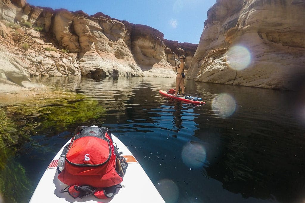 Brooke standing on her paddleboard in the flooded section of Antelope Canyon with a Dry Bag sitting on the front of Buddy's board