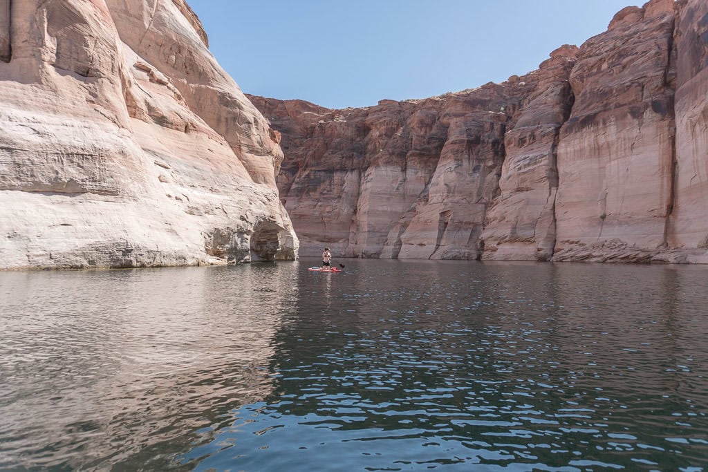 Brooke Paddleboarding on Lake Powell between giant rock cliffs on the way to Antelope Canyon in Page Arizona